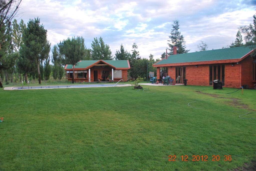 a house with a large yard next to a building at Mi Paraiso in Quillón