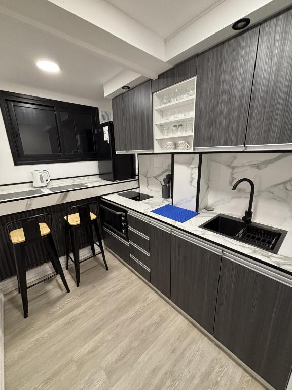 a kitchen with wooden cabinets and a sink and chairs at Montevideo Centro in Montevideo