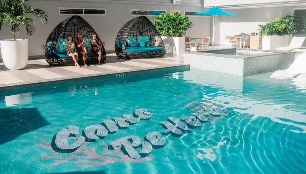 a group of people sitting on chairs next to a swimming pool at OUTRIGGER Waikiki Paradise Hotel in Honolulu