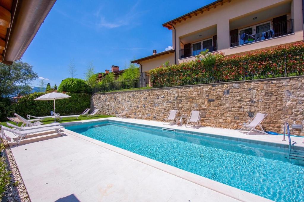 a swimming pool in front of a house at Como Lake Modern Apartament Ulivi in Mezzegra