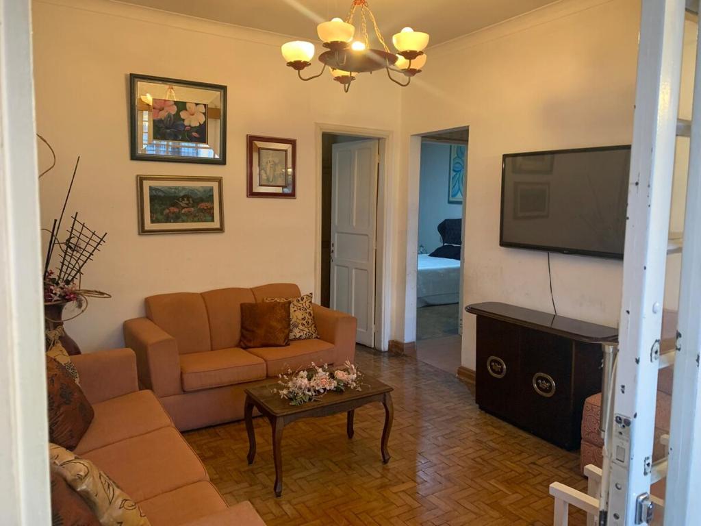 a living room with a couch and a flat screen tv at Casa completa com vaga de garagem 2 quartos in Campinas