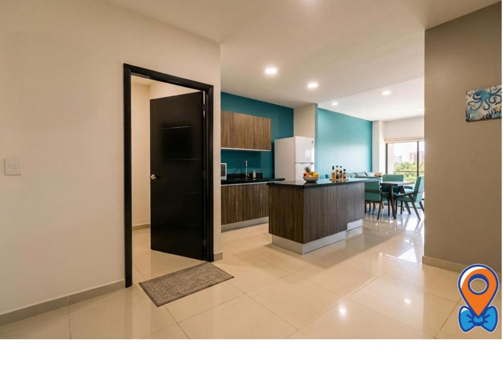 a kitchen with a black door leading to a dining room at Depa Amplio Vista al Mar Cerca del Malecón in Mazatlán