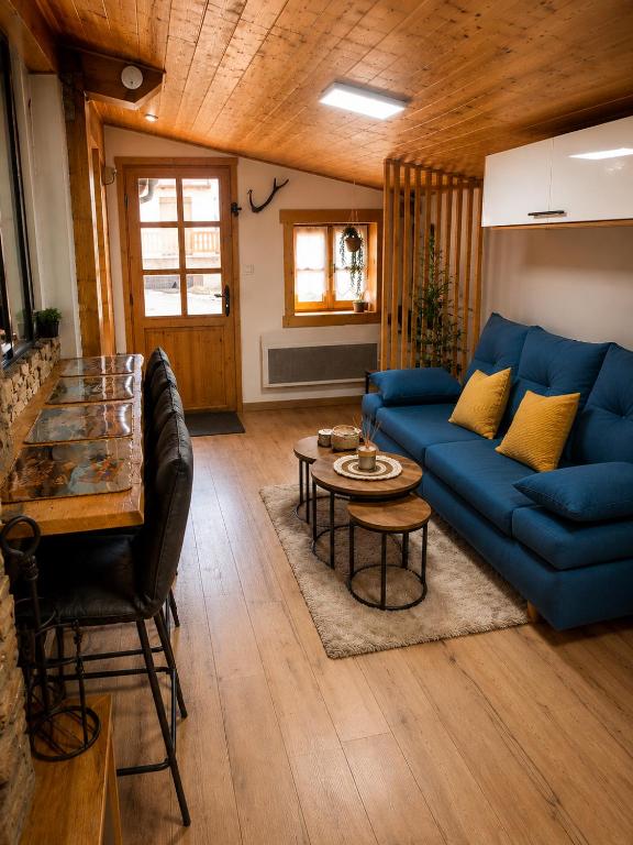 a living room with a blue couch and a table at Maisonnette Cosy in La Llagonne