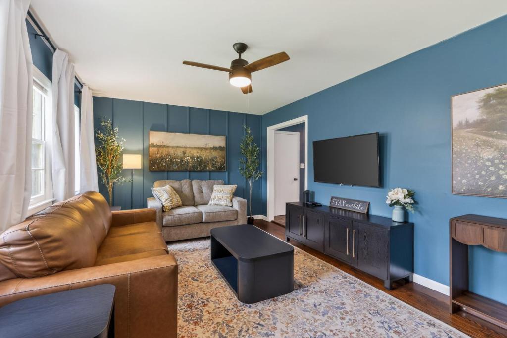 a living room with a couch and a flat screen tv at Chic Home with Huge Grassy Yard 7 mins to Arrowhead Stadium in Independence