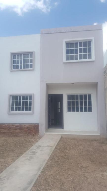 ein weißes Haus mit drei Fenstern und einer Tür in der Unterkunft Casa Manu in Mérida