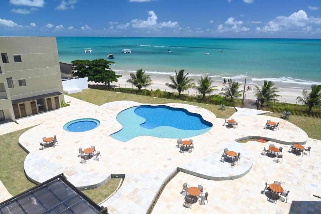 an aerial view of a pool and the beach at Maragogi Praia Hotel in Maragogi