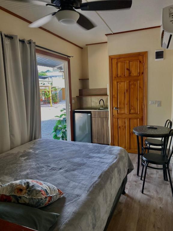 a bedroom with a bed and a table and a kitchen at Chill Studio Near Beach Tamarindo in Tamarindo