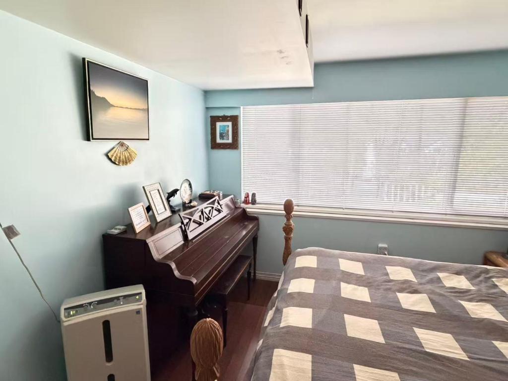 a bedroom with a piano and a bed and a window at Cozy EnSuite No Pets Allowed in Burnaby
