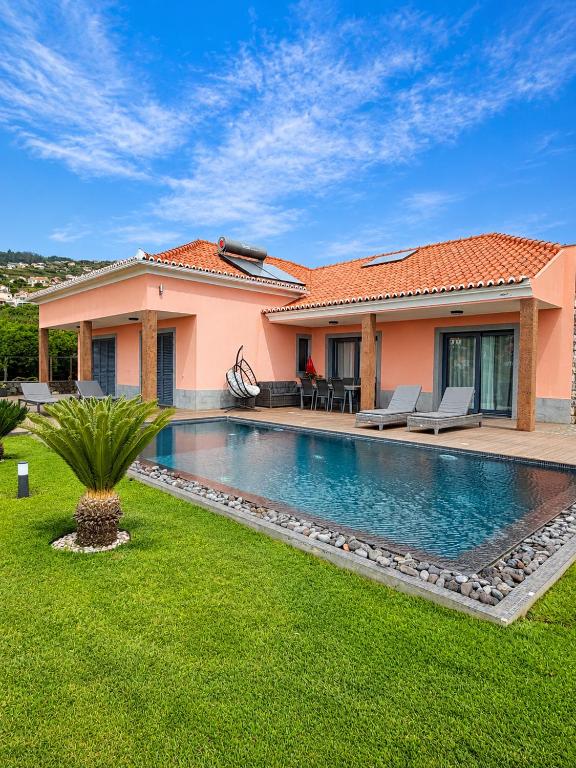 a house with a swimming pool in a yard at Villa Livramento in Ponta do Sol