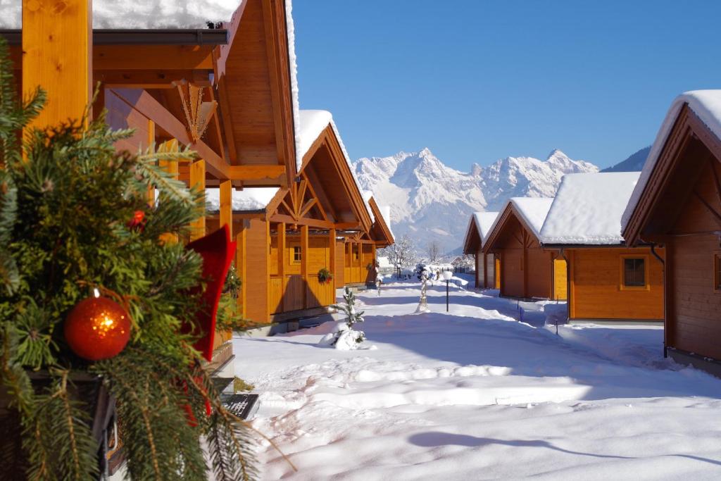 a snow covered street in a town with snow covered buildings at Feriendorf Oberreit in Maishofen