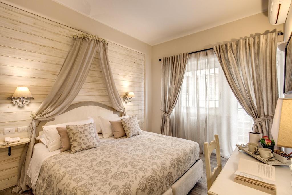 a bedroom with a bed and a desk and a window at Casa Mia Vaticano Guest House in Rome