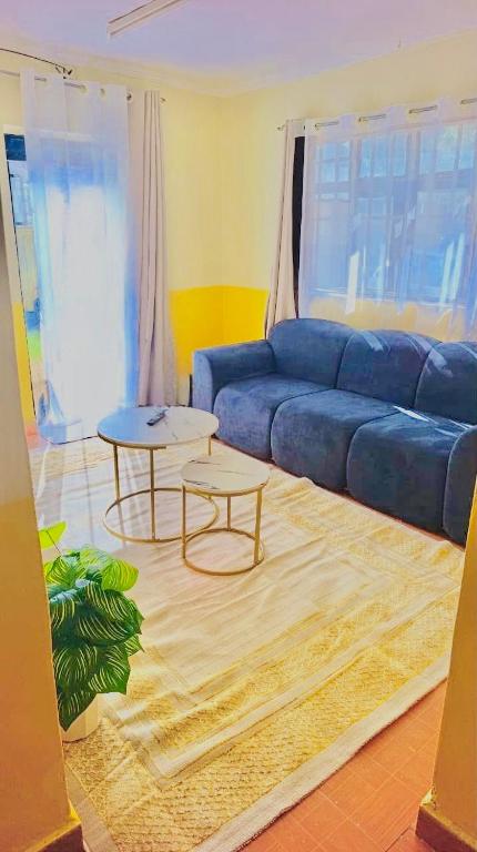 a living room with a blue couch and a table at Tranquil stays - 1 modern 1 bedroom apartment along Kandunyi Highway in Longonot