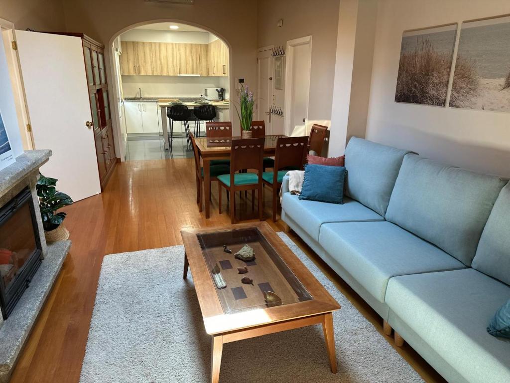 a living room with a blue couch and a table at Rincón Atlántico ático deluxe in Moaña