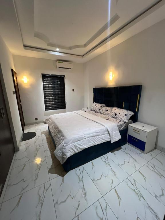 a bedroom with a large bed with marble floors at Velaris Luxury Apartment in Port Harcourt