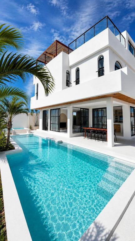 a villa with a swimming pool in front of a house at Villa Atlantica - Preá in Prea