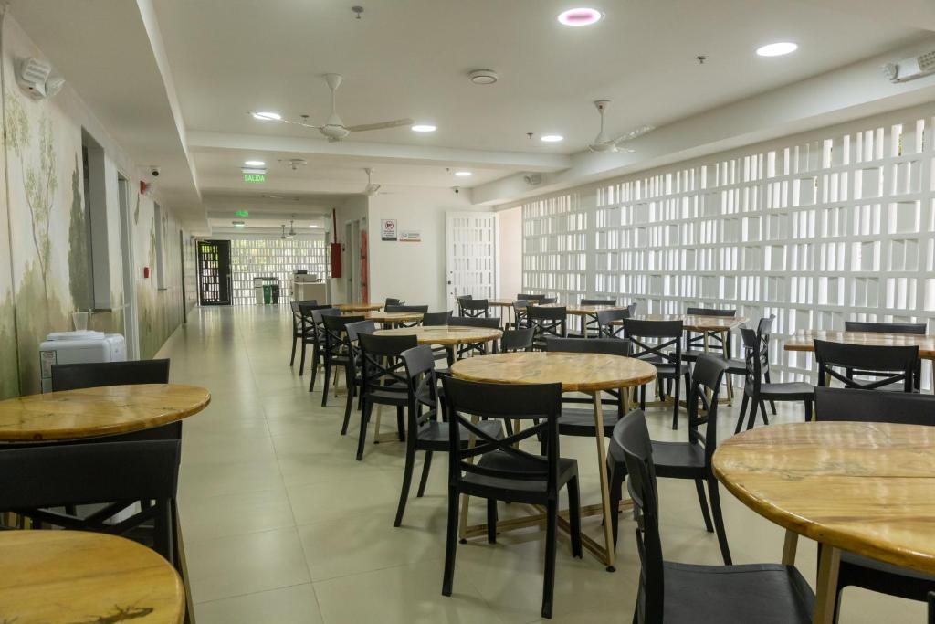 a restaurant with tables and chairs in a room at Student Site - Coliving Hotel in Montería