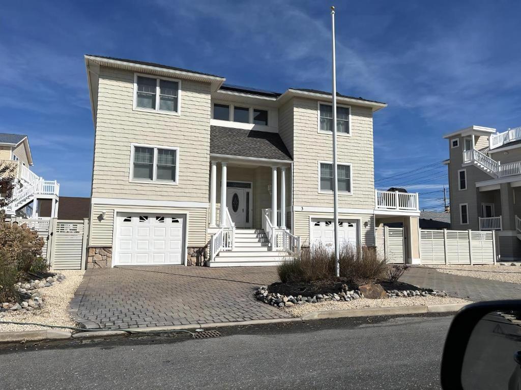 a house with a white fence in front of it at Bayside Gem in Beach Haven Crest