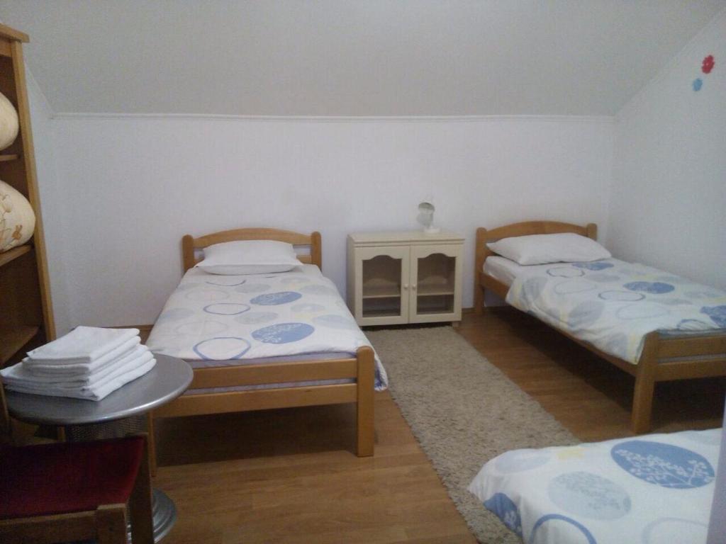 Habitación pequeña con 2 camas y mesa. en Guest House Star, en Međugorje
