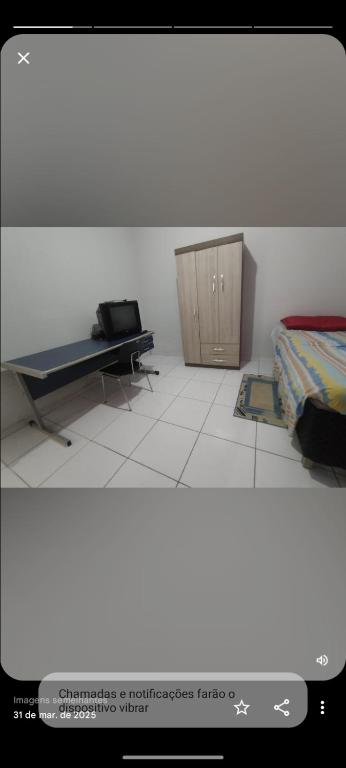 a bedroom with a bed and a wooden cabinet at Pousada de Sá in Uberlândia