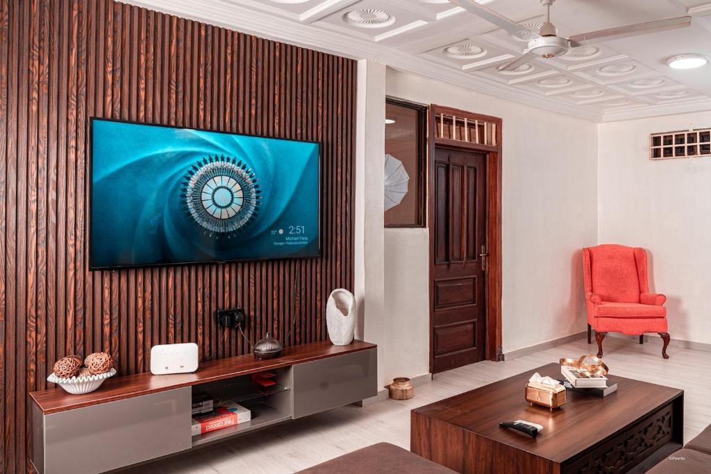 a living room with a television on a wall at Kumbaya Apartments in Achimota
