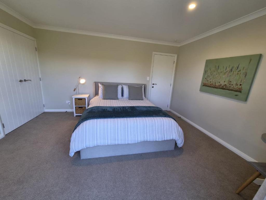 a bedroom with a large bed and a painting on the wall at Monarch Park Studio in Cambridge