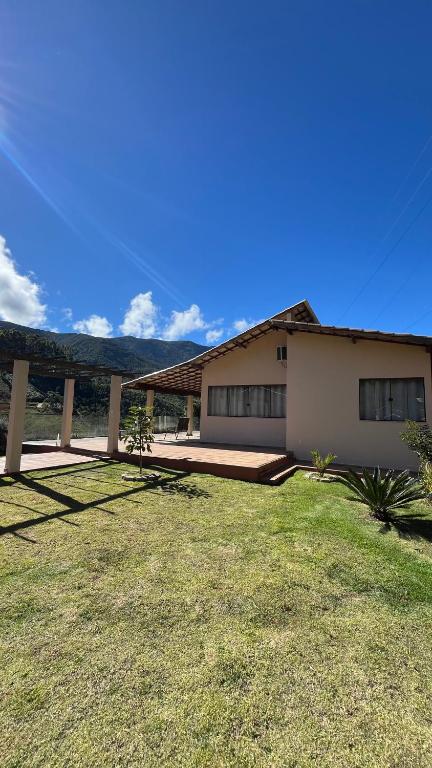 a house with a grass yard in front of it at Refúgio do ipê in Pedra Menina