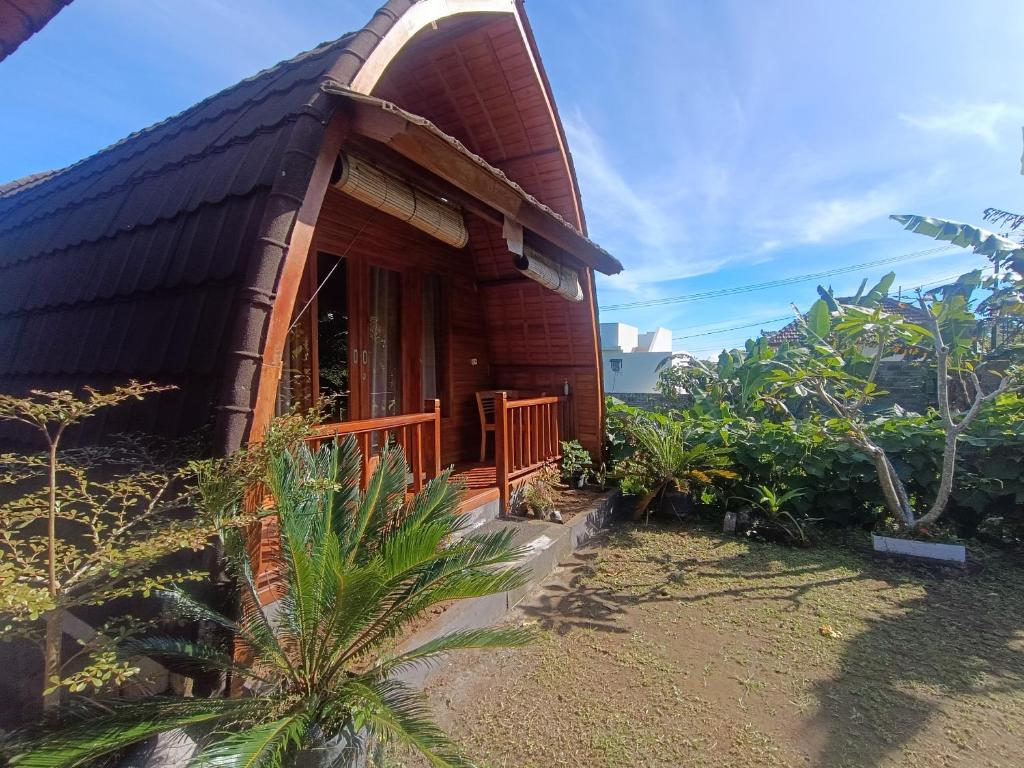 a small house with a thatch roof at Pondok DG and Spa in Munduk