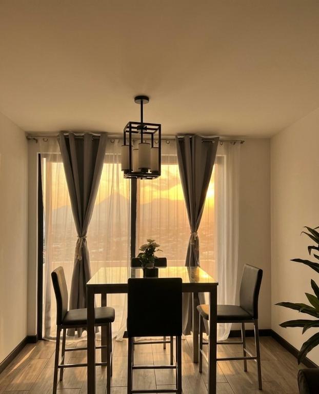 a dining room table with chairs and a chandelier at Escápate- Roomgt in Boca Monte