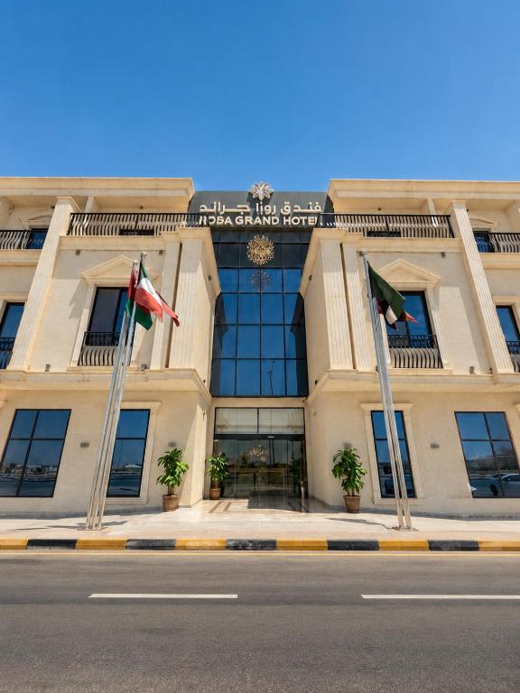 a building with three flags in front of it at Rosa Grand Hotel in Riyadh