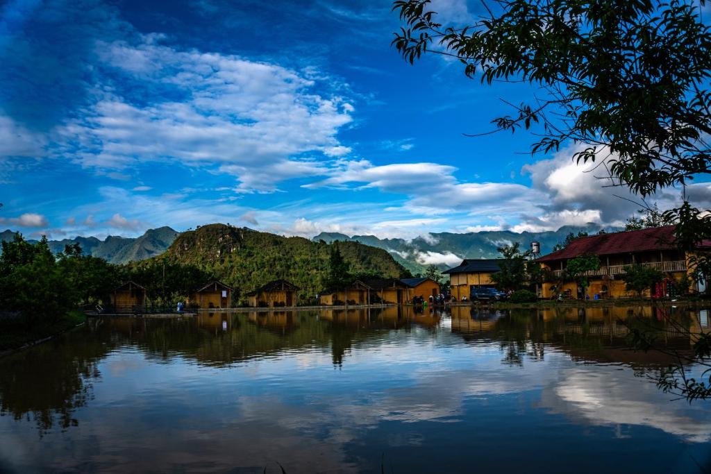 a view of a lake with houses and mountains at Toong homestay in Ha Giang
