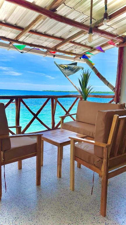 a patio with a table and chairs and the ocean at MANDA PARaDISE HOUSE in Cartagena de Indias