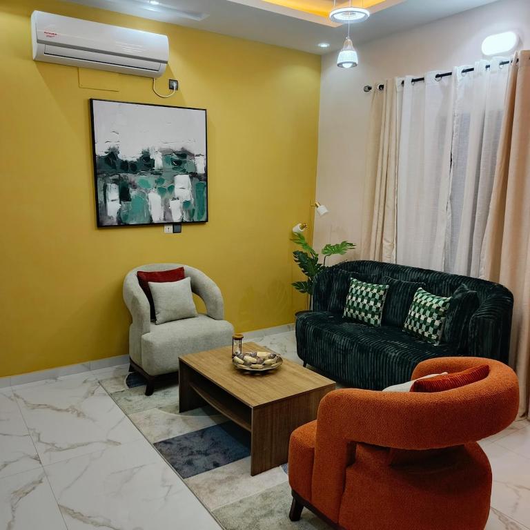 a living room with a couch and two chairs and a table at Le Cocon coloré Work and Chill KÉgué in Avéimé