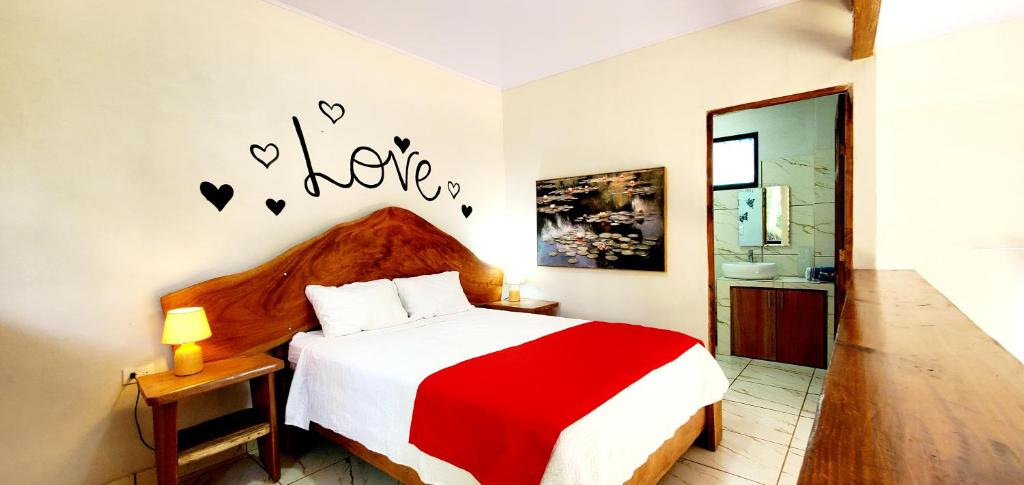 a bedroom with a red and white bed and a bathroom at Romantic Suite with Pool in Fortuna