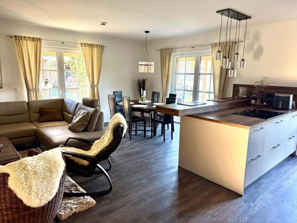 a kitchen and living room with a couch and a table at Grodehus-Eigener-Bungalow in Haby