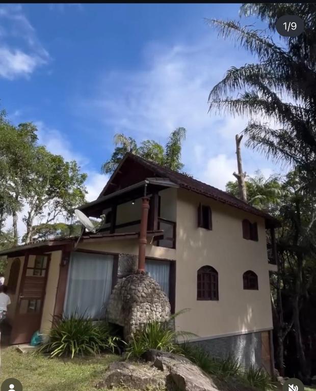 a house with a palm tree in front of it at Espaço Colibri in Teresópolis