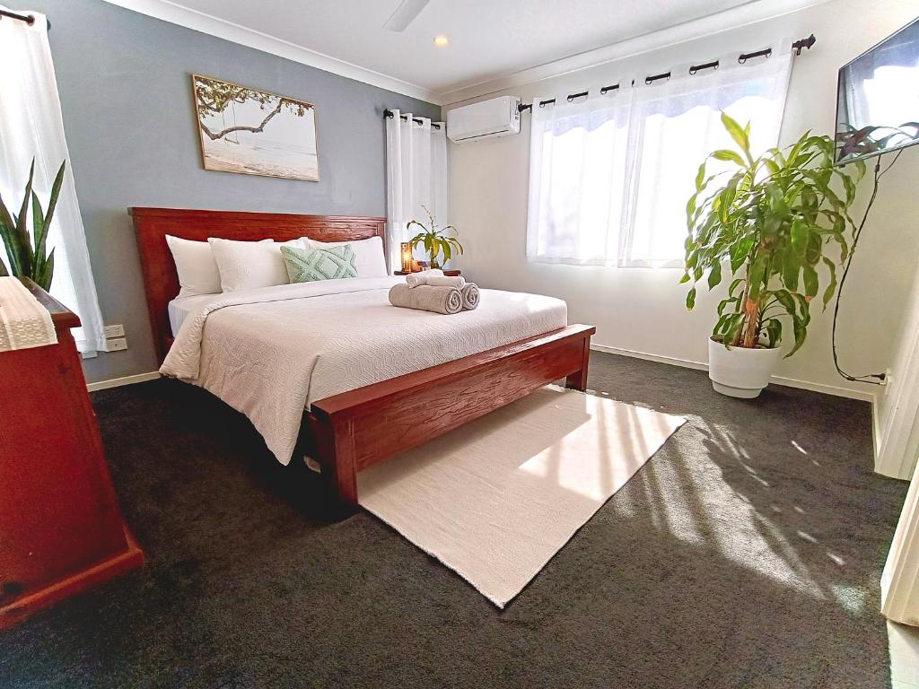 a bedroom with a bed and two potted plants at Executive King Suite - Ensuite in Holmview