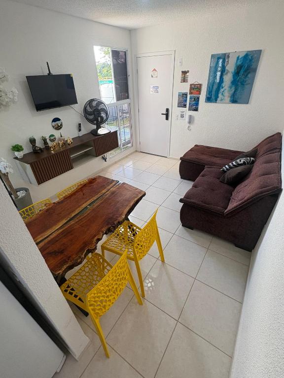 a living room with a wooden table and a couch at Aconchego estrada do coco in Camaçari