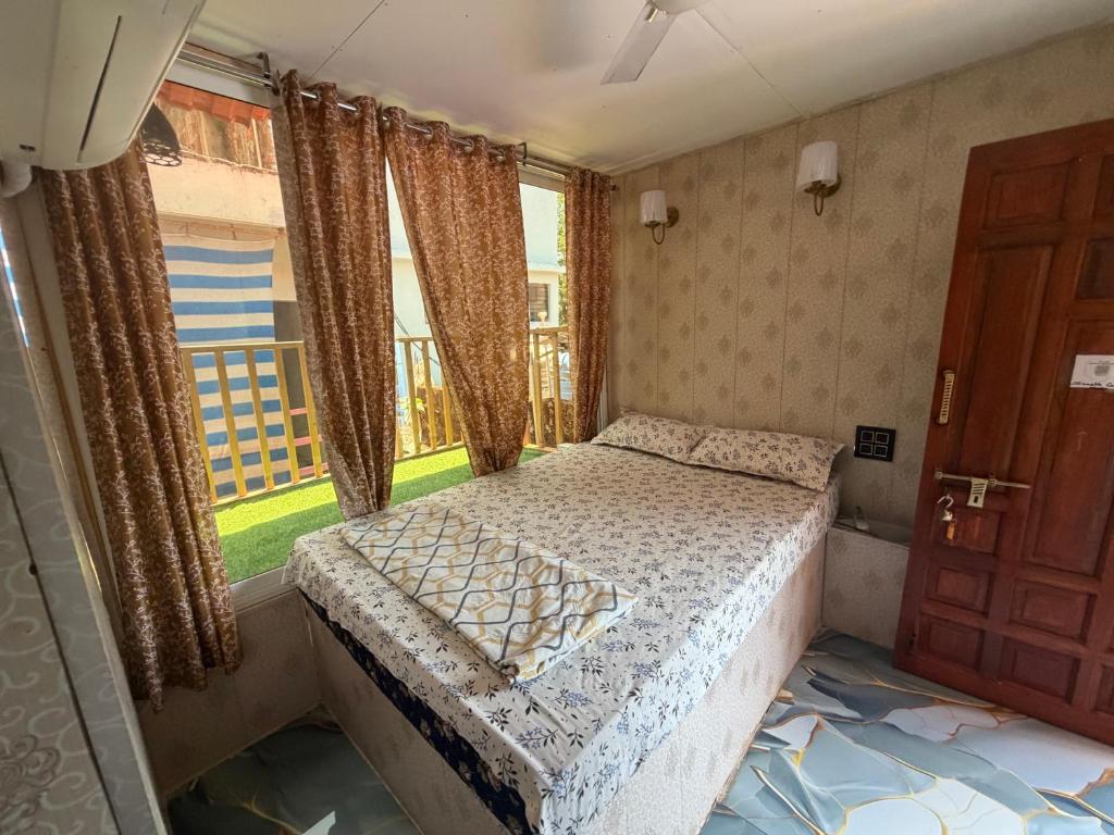 a bedroom with a bed in front of a window at Swastik Guest House in Arambol