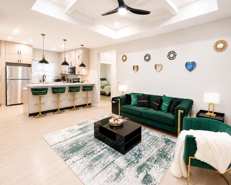 a living room with a green couch and a kitchen at Gold'n Retreat in Mission