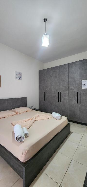 a bedroom with a large bed with two towels at Mali's Apartment in Tirana