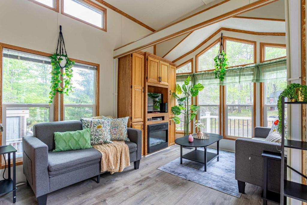 a living room with a couch and a table at The Nook Tiny Home Fire Pit Close to Lake in Maple Lake