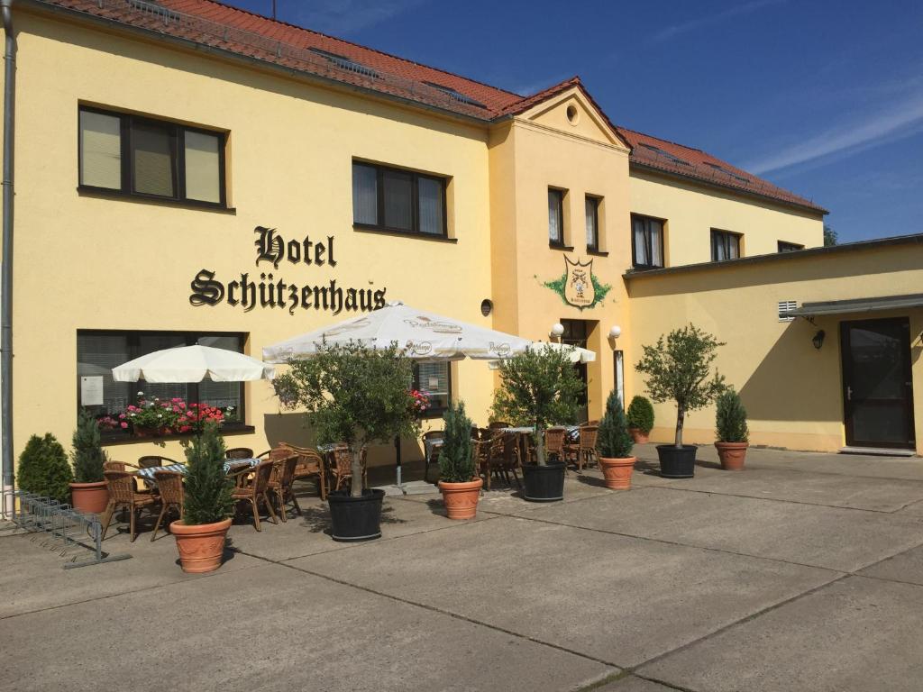 ein Restaurant mit Tischen und Stühlen vor einem Gebäude in der Unterkunft Hotel Schützenhaus in Brück