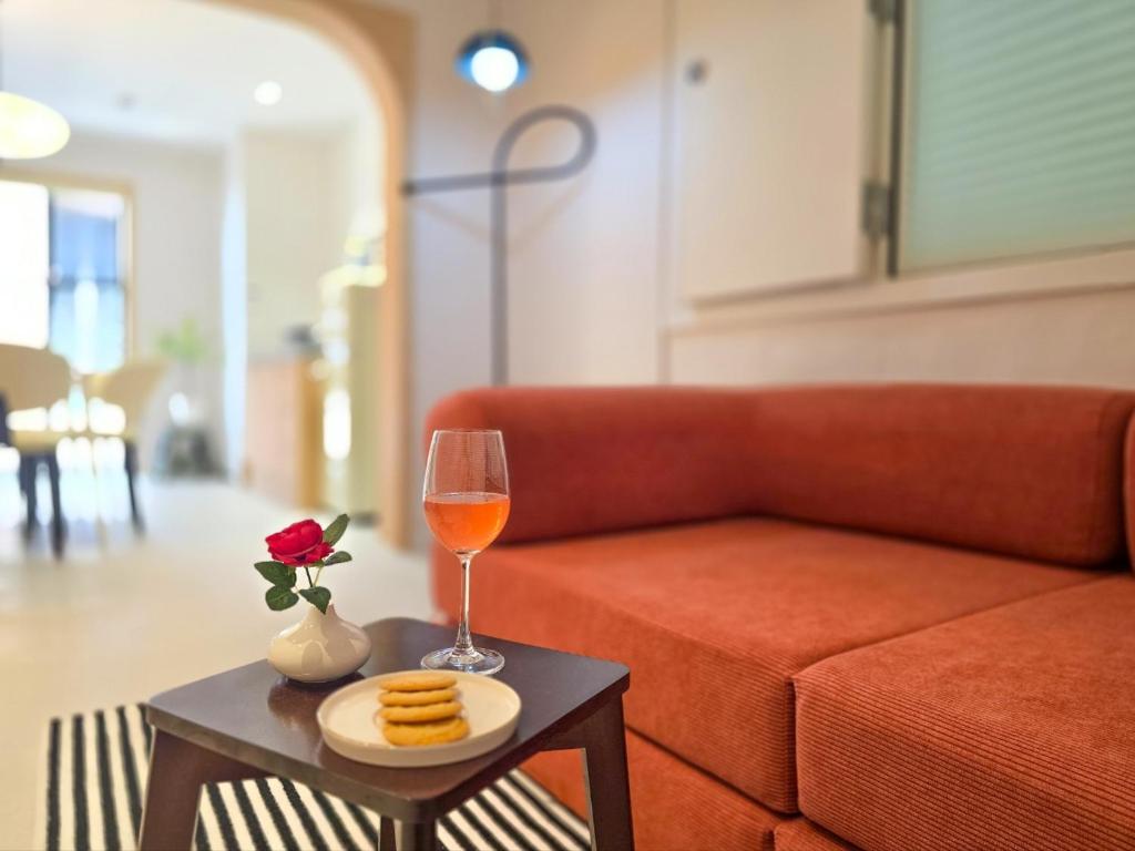 a glass of wine on a table next to a couch at 스테이동백 in Jeonju