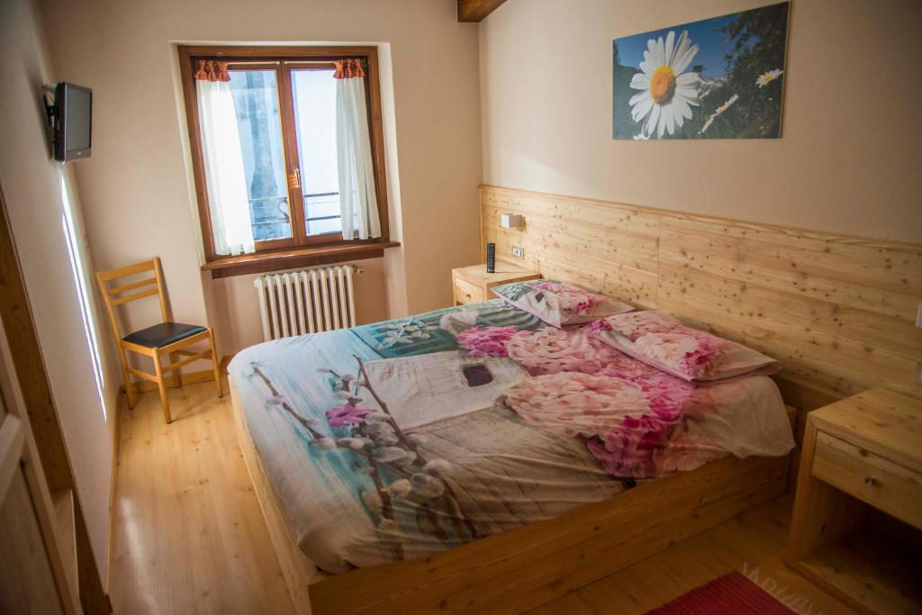a bedroom with a bed with flowers on it at Albergo K2 in Madesimo