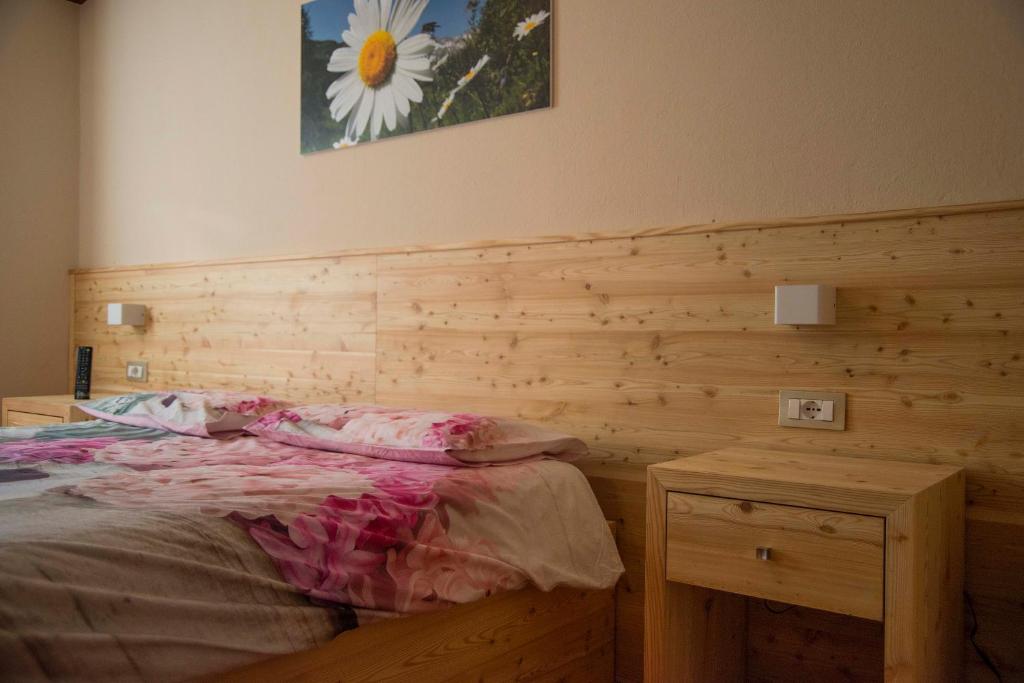 a bedroom with a bed and a wooden wall at Albergo K2 in Madesimo
