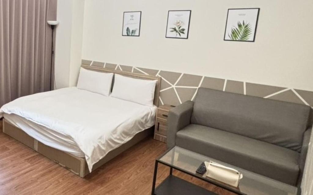 a small bedroom with a bed and a couch at Still Haus 静の宿 in Taichung