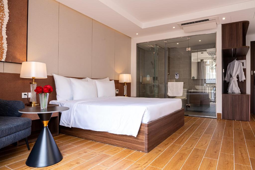 a hotel room with a bed and a bathroom at Devesun Boutique Hotel Phú Quốc in Phú Quốc