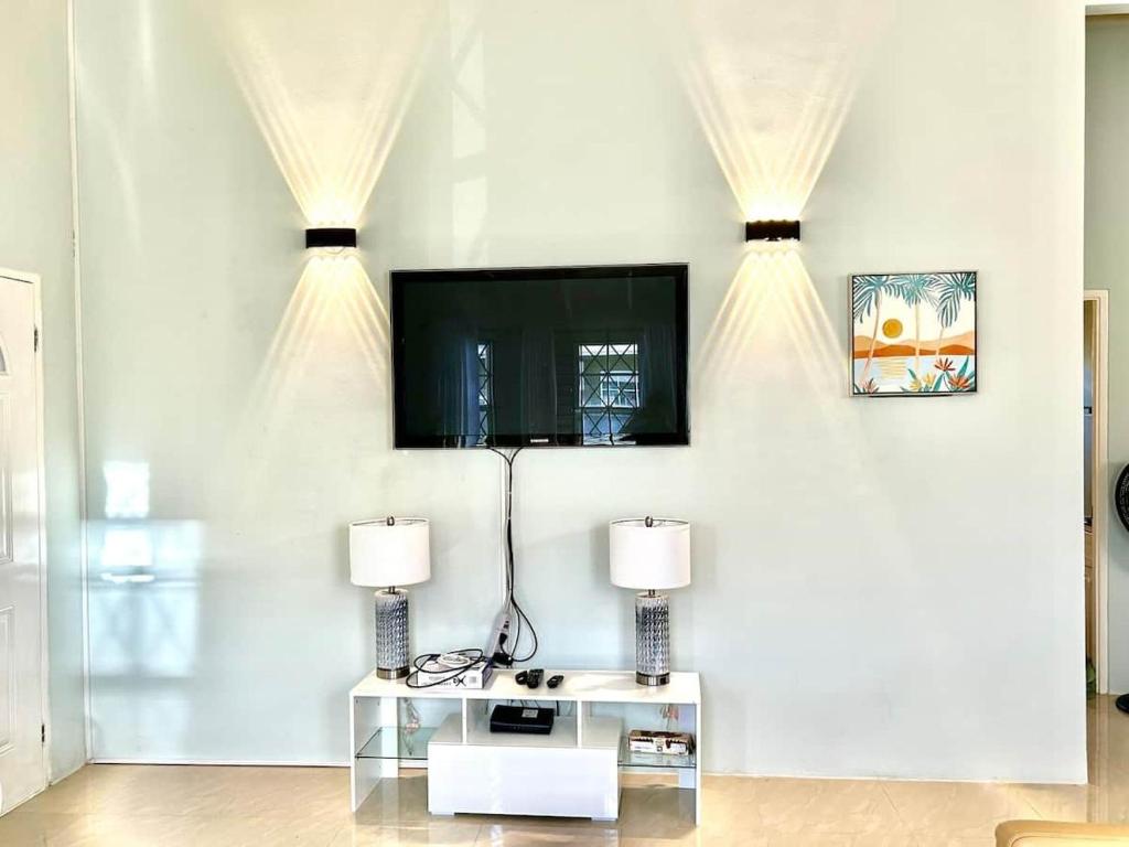 a living room with a tv on a white wall at Soulful Serenity in Steer Town
