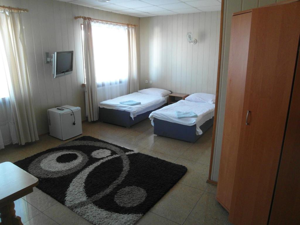 Habitación pequeña con 2 camas y alfombra. en Pomorska Zajazd Restauracja en Czaplinek