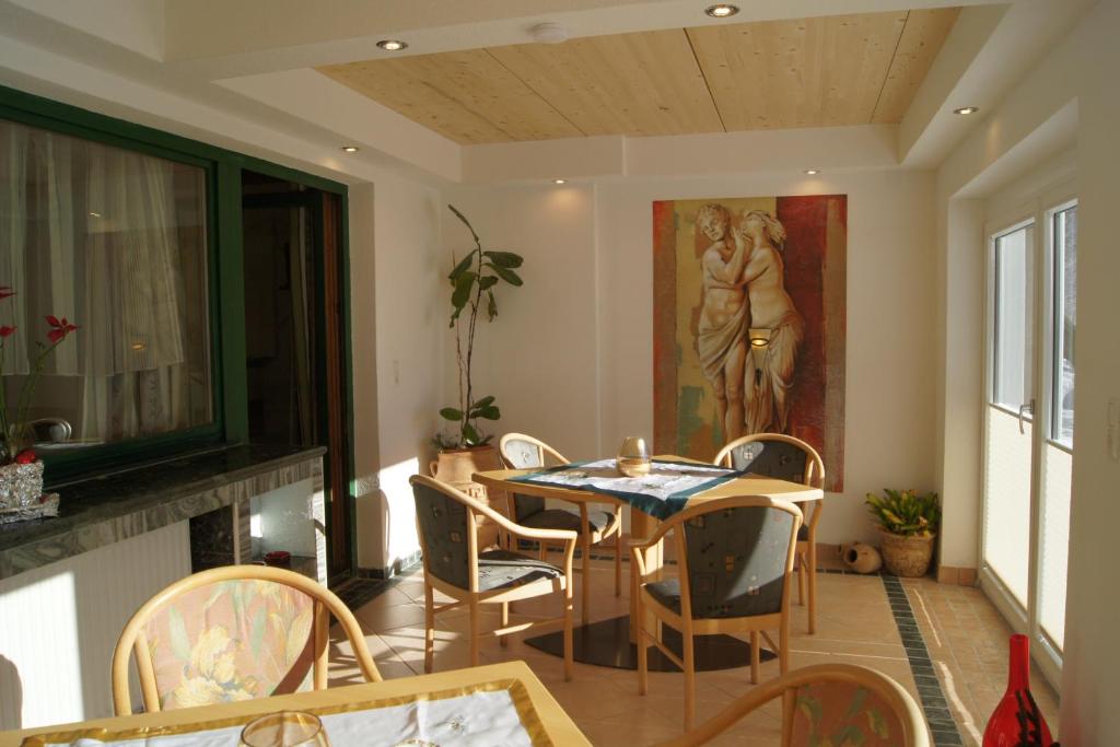 a dining room with a table and chairs and a painting at Familienferienhaus Florentine in Längenfeld